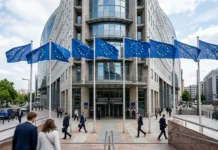 EU Approves €3.47B Defense Fund for Ukraine مبنى المفوضية الأوروبية وأعلام الاتحاد الأوروبي في بروكسل تعبيراً عن التمويل الدفاعي لأوكرانيا