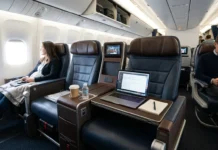 United Airlines’tan Boş Orta Koltuk Devrimi ve Yeni Konsept مقصورة طائرة تظهر مقعداً أوسط شاغراً ومجهّزاً بسطح عمل جلدي وحوامل أكواب
